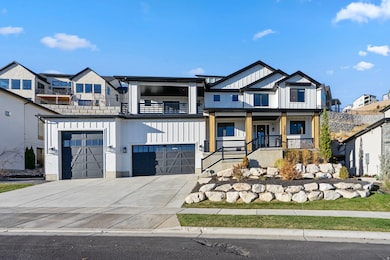 Modern farmhouse with driveway, a garage, covered porch, and board and batten siding
