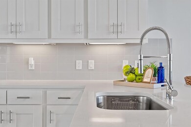 Kitchen view of a sink, white cabinetry, light co