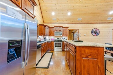 Kitchen with visible vents, brown cabinets, stainless steel appliances, a kitchen island, and a sink