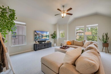 Carpeted living room featuring a ceiling fan, bas
