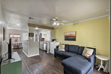 Living room featuring ornamental molding, dark woo