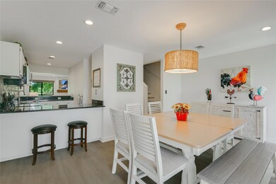 Dining area with light wood-style floors, stairs,