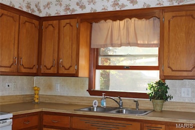 Kitchen featuring brown cabinets, backsplash, and light countertops
