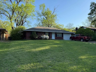 Single story home with a garage, a front yard, and