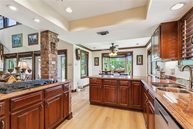 Large kitchen has plenty of storage, Jenn Air gas cooktop, granite countertops and informal dining