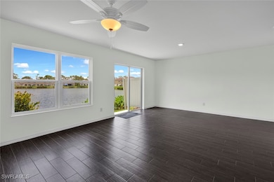 Spare room featuring a water view, dark wood-type flooring, and ceiling fan