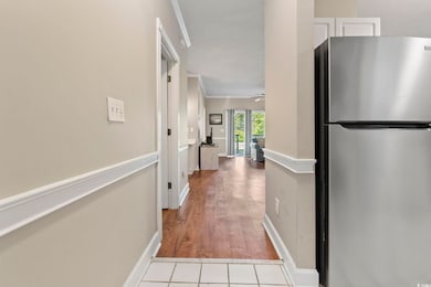 Hall with baseboards, ornamental molding, and wood