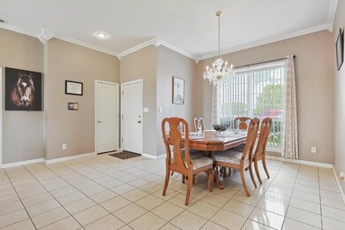 Dining space with a chandelier, ornamental molding, and light tile patterned floors