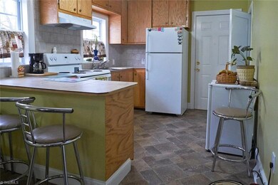 Updated vinyl floors and tile counter tops in kitchen.  Refrigerator remains.