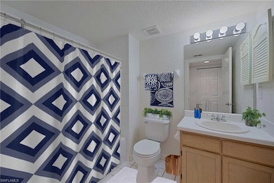 Bathroom featuring vanity, toilet, a textured ceiling, curtained shower, and a textured wall