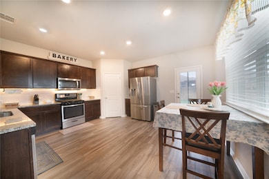 Kitchen with stainless steel appliances, dark bro