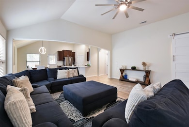 Living area with ceiling fan, lofted ceiling, arc