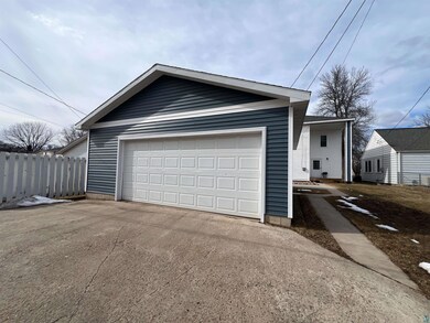 Garage featuring driveway and fence