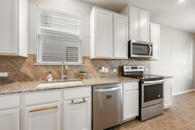 Kitchen featuring tasteful backsplash, white cabi