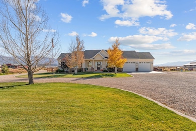 View of front of home featuring driveway, a front yard, covered porch, and a garage