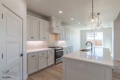 Kitchen featuring sink, stainless steel range with
