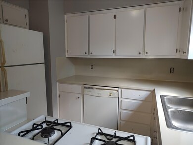 Kitchen featuring white appliances, light counter