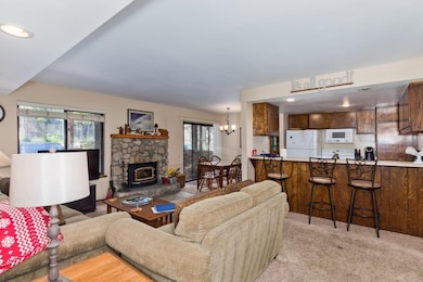 Living area with recessed lighting, a chandelier, and light carpet