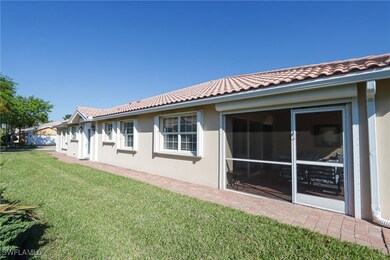 Back of house with stucco siding, a tile roof, and