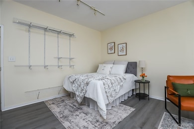 Bedroom with track lighting and dark hardwood / wo