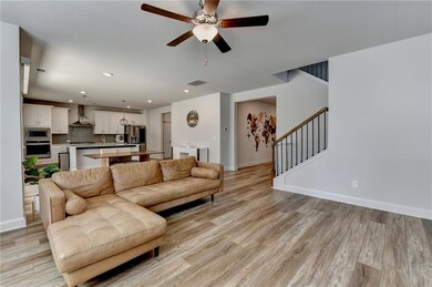 Living area featuring a ceiling fan, light wood-st