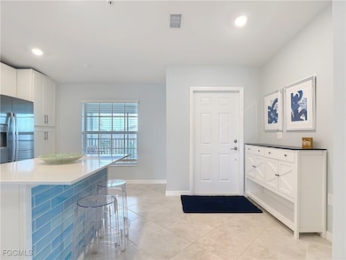 Entryway with light tile patterned flooring and recessed lighting