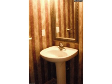 A pedestal sink adorns the convenient half bath on