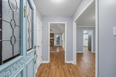 Entryway featuring light wood-type flooring and a large fireplace