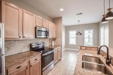 Kitchen with backsplash, light tile floors, pendan