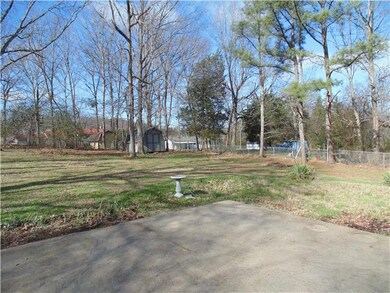 Back view of fenced in yard with storage shed