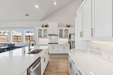 Kitchen with sink, white cabinets, lofted ceiling,