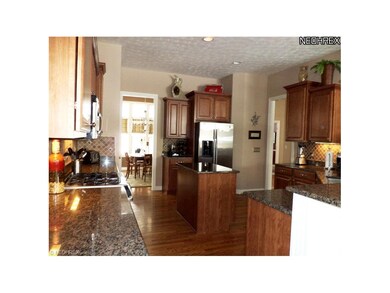 Custom kitchen with warm wood cabinetry, hardwood 