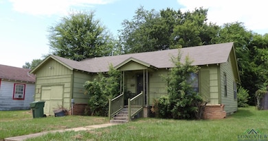 Ranch-style home with roof with shingles and a front yard