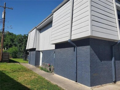 View of property exterior featuring brick siding and a yard