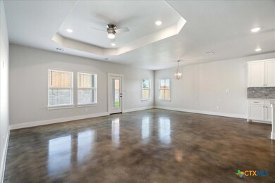 A sun-filled living room with a high tray ceiling,