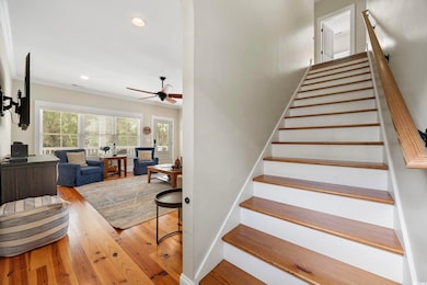 Stairway featuring ceiling fan, hardwood / wood-style flooring, recessed lighting, and ornamental molding