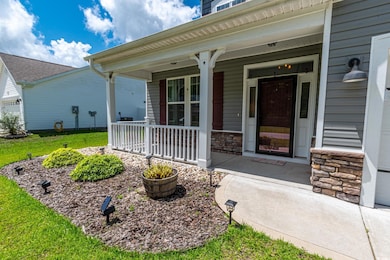 Doorway to property featuring covered porch, stone