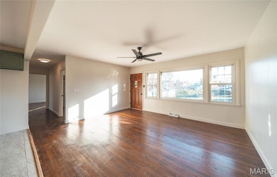 Unfurnished living room with dark wood-style flooring and ceiling fan