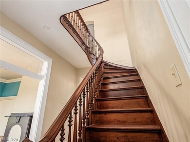 Staircase featuring ornamental molding and a high ceiling