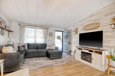 Living area with vaulted ceiling and light wood-ty