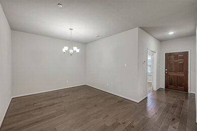 Spacious room with hardwood floors and modern ligh