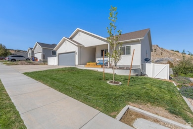 Single story home with stucco siding, driveway, a gate, and a garage