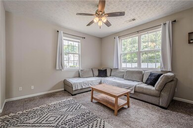 Living area with ceiling fan, baseboards, light co