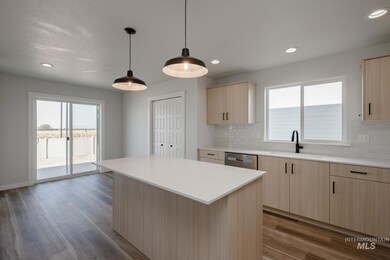 Kitchen with light brown cabinets, tasteful backsplash, a kitchen island, light wood finished floors, and recessed lighting