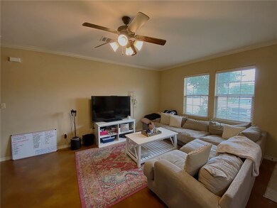Living area featuring a ceiling fan, crown molding