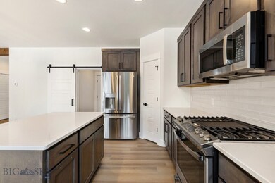 Kitchen featuring tasteful backsplash, dark brown