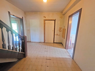 Hallway with tile patterned floors, ornamental molding, and stairs
