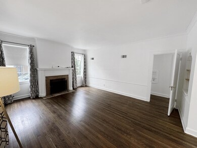 Unfurnished living room with crown molding, a fire