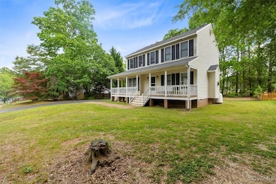 Back of house featuring a porch and a yard