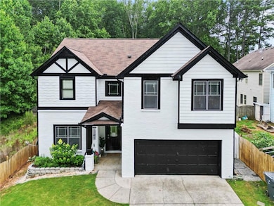 View of front of home featuring a garage, driveway, brick siding, and roof with shingles